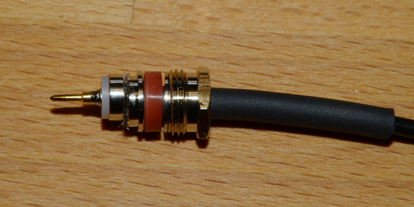 Abbildung 14: Der Mittelstift muss auf den Innenleiter gelötet werden. Man kann den Stift in einem Schraubstock ﬁxieren, dann wird er innen mit Lötzinn verzinnt. Auch der Innenleiter des Koaxkabels wird minimal verzinnt. Der Teﬂonhalter wird mit den Fingern ﬁxiert, der Steckermittelstift gleichzeitig mit dem Lötkolben erwärmt und der steife Innenleiter des Koaxkabels wird von hinten in den Mittelstift gesteckt bis das Lötzinn schmilzt und der Innenleiter tiefer in den Mittelstift eindringt.